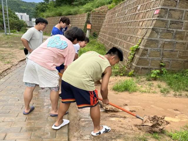 实践队与沈阳理工大学同学共同清理暴雨后土窑洞住处前堆积的淤泥 实践队与沈阳理工大学同学共同清理暴雨后土窑洞住处前堆积的淤泥